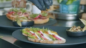 Chef garnishing avocado toast microgreens — EVEC microgreens methodology