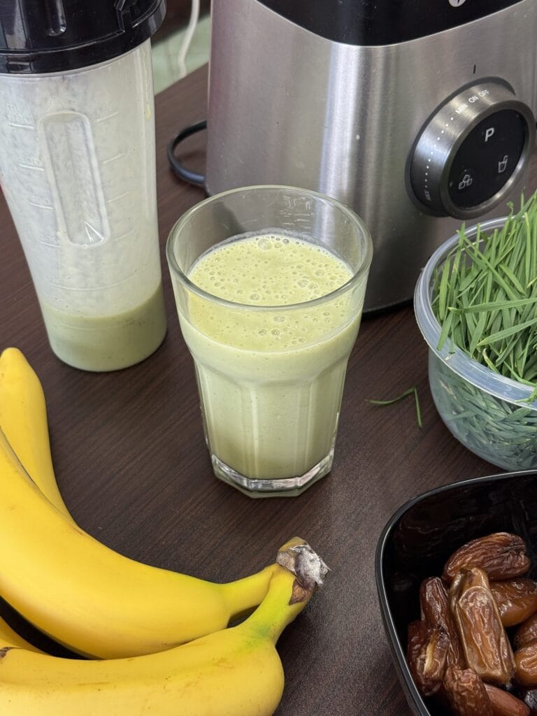 Preparing a wheatgrass smoothie with fresh ingredients